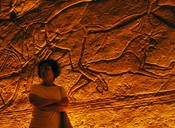 Inside Rameses' Temple, Gloria stands before the relief.