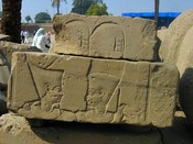 In this stone, one of many piled outside the temple, Pharaoh raises his hand in adoration of the god, who puts his arm on Pharaoh's shoulder in acceptance.