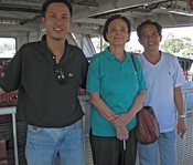 Gloria on the ferry, between Tham, our guide, and Tham, our driver