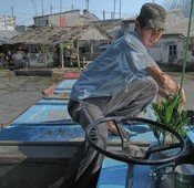 Our second-day boat driver, with a good-luck pre-Tet plant